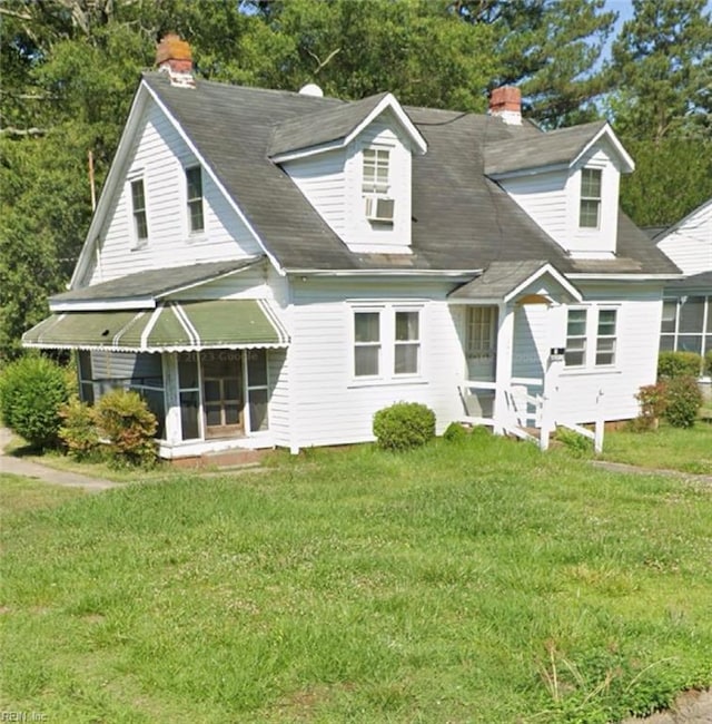 new england style home featuring cooling unit and a front lawn