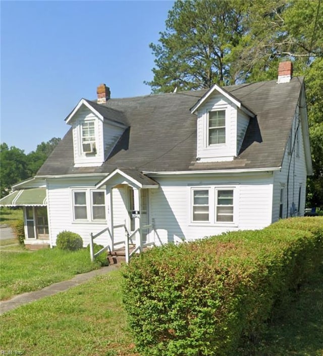 cape cod home with a front yard