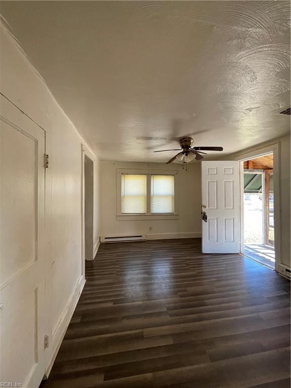 unfurnished room with ceiling fan, baseboard heating, dark wood-type flooring, and a textured ceiling