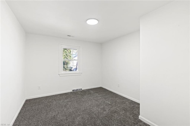 unfurnished room with dark carpet