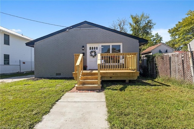 view of front of home featuring a front yard and a wooden deck