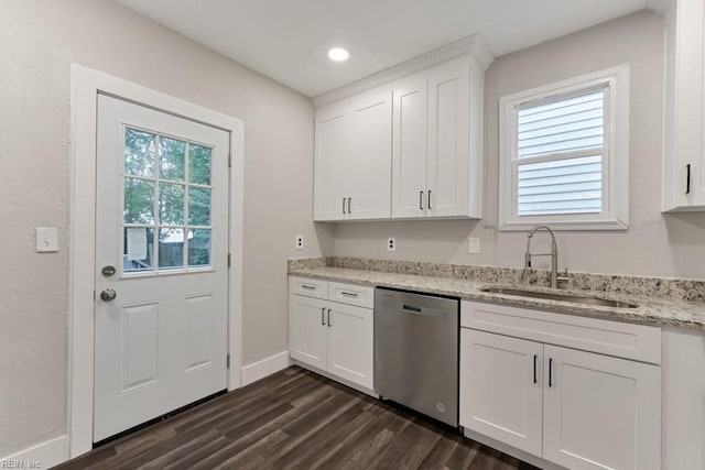 kitchen with stainless steel dishwasher, light stone counters, white cabinets, and sink