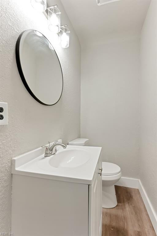 bathroom featuring toilet, vanity, and hardwood / wood-style flooring