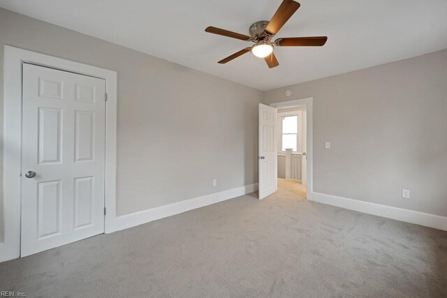 carpeted empty room featuring ceiling fan