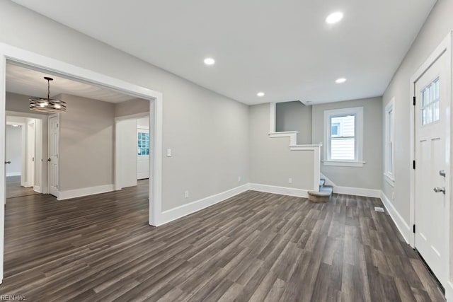 spare room with dark hardwood / wood-style flooring and a notable chandelier