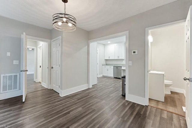 unfurnished dining area featuring dark hardwood / wood-style flooring and a chandelier