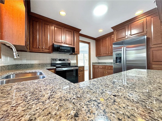 kitchen with light stone countertops, sink, and appliances with stainless steel finishes