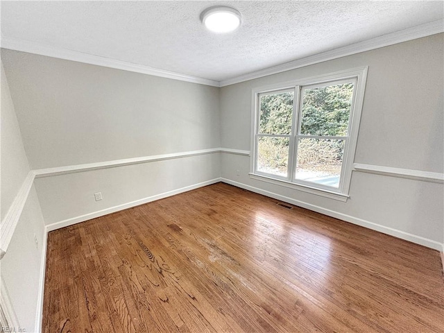 spare room with hardwood / wood-style floors, crown molding, and a textured ceiling