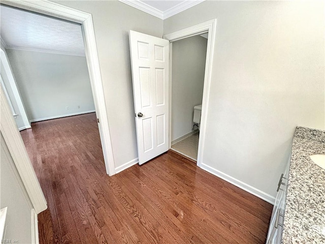 hallway featuring dark wood-type flooring and ornamental molding