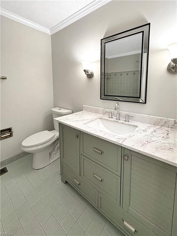 bathroom with tile patterned floors, vanity, toilet, and a textured ceiling