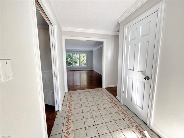 hallway featuring light tile patterned floors and crown molding