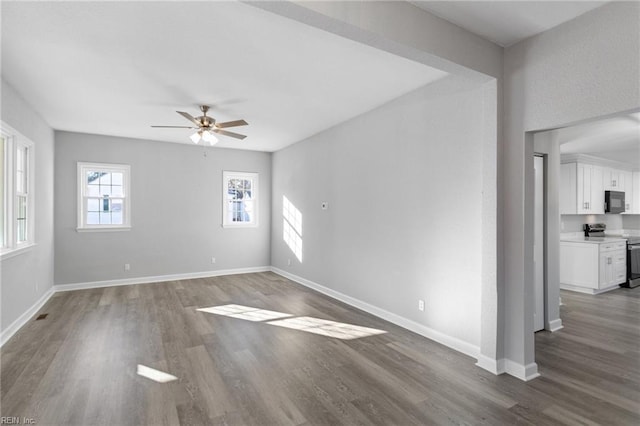 empty room with ceiling fan and dark wood-type flooring