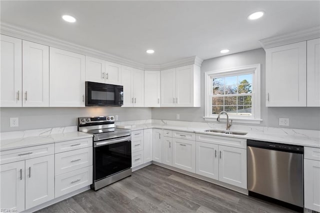 kitchen with white cabinetry, sink, stainless steel appliances, and hardwood / wood-style flooring