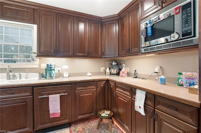 kitchen featuring dark brown cabinets, built in microwave, and sink