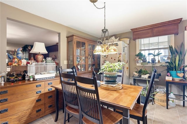 dining space featuring light tile patterned flooring and a chandelier