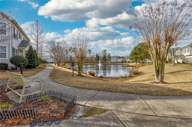 view of home's community with a yard and a water view