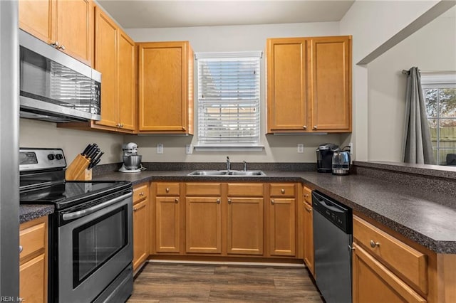 kitchen featuring kitchen peninsula, sink, stainless steel appliances, and dark hardwood / wood-style floors