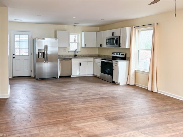 kitchen featuring light wood-type flooring, white cabinetry, and stainless steel appliances