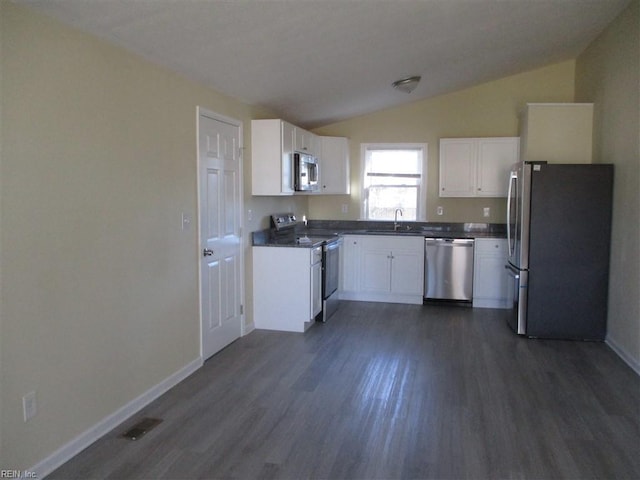 kitchen featuring vaulted ceiling, stainless steel appliances, dark wood-type flooring, white cabinets, and sink