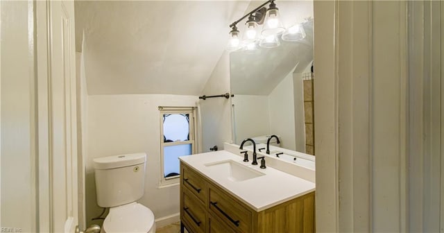 bathroom featuring vanity, lofted ceiling, and toilet