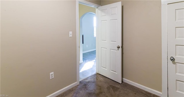 corridor featuring dark colored carpet