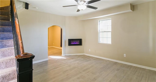 unfurnished living room featuring wood-type flooring and ceiling fan