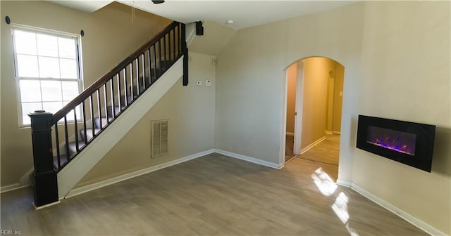 staircase featuring a wealth of natural light and wood-type flooring