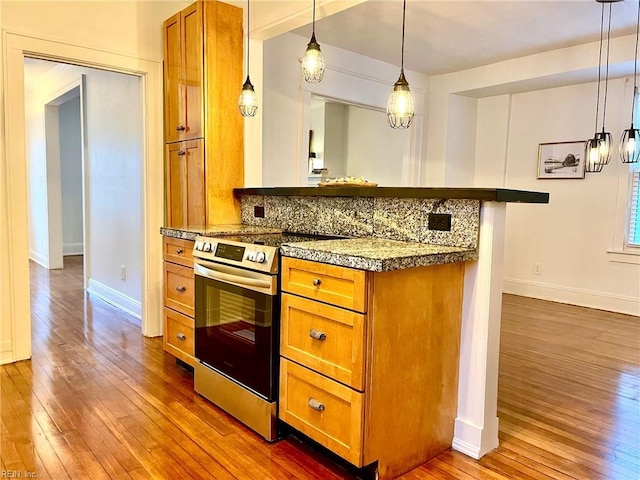 kitchen with kitchen peninsula, backsplash, dark hardwood / wood-style floors, stainless steel electric stove, and hanging light fixtures