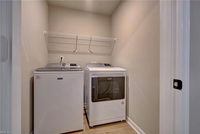 laundry room featuring light wood-type flooring and separate washer and dryer