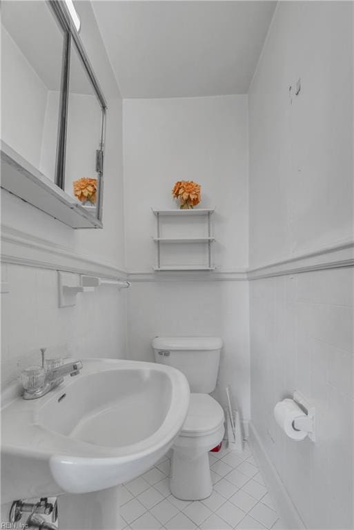 bathroom with toilet, tile patterned floors, and sink