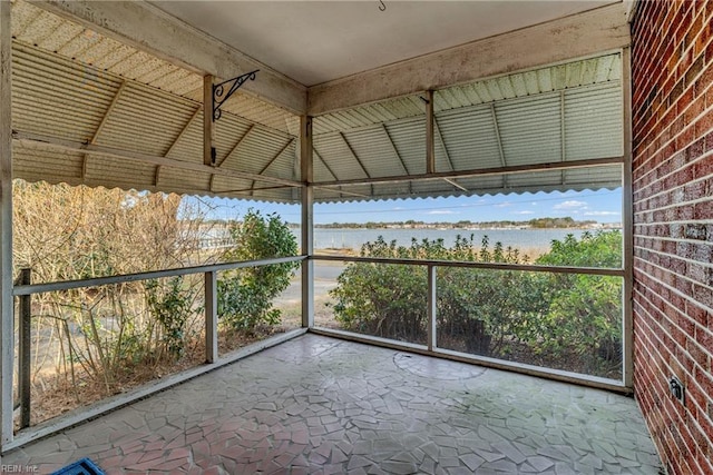 unfurnished sunroom with a water view