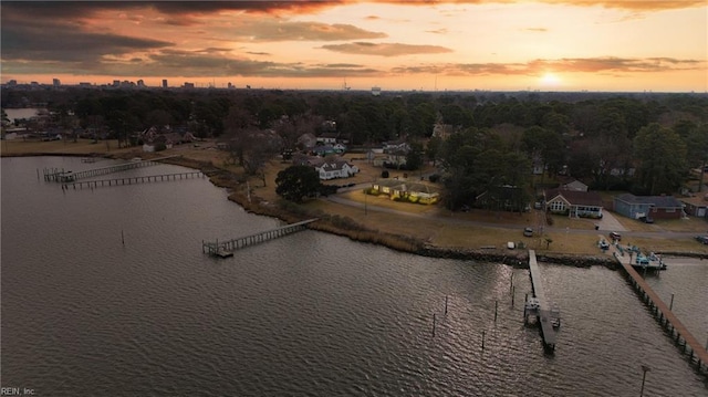 aerial view at dusk featuring a water view