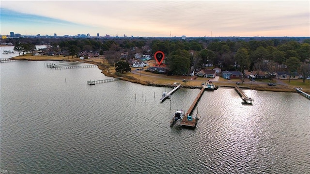 aerial view at dusk featuring a water view