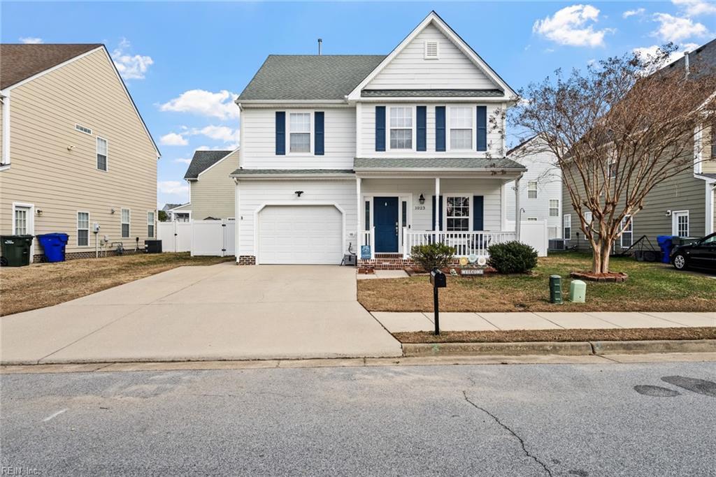 front of property with a front yard, a porch, and a garage