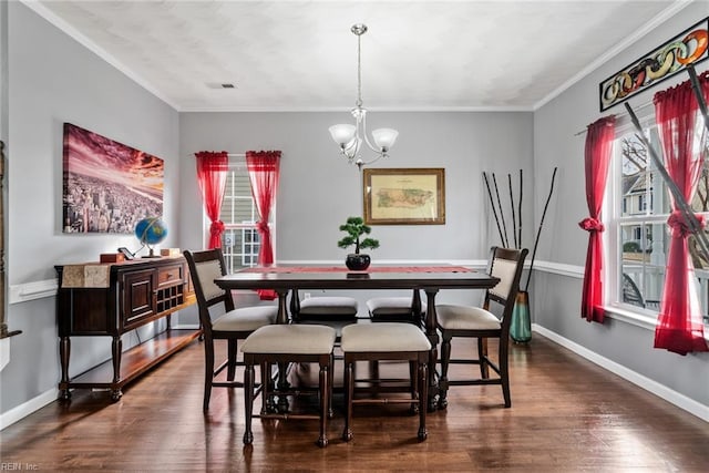 dining area featuring dark wood-type flooring, ornamental molding, and a notable chandelier