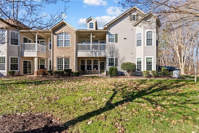 rear view of house featuring a yard and ceiling fan