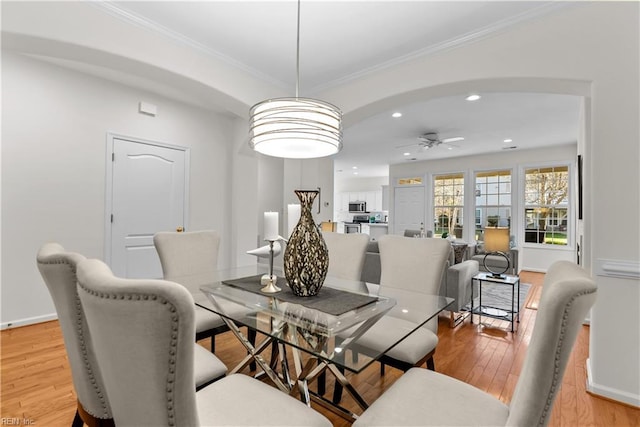 dining space featuring ceiling fan, light hardwood / wood-style floors, and ornamental molding