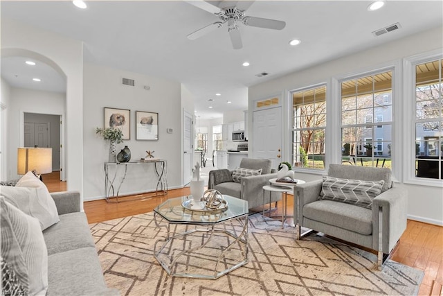 living room with ceiling fan and light hardwood / wood-style flooring