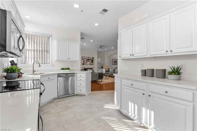 kitchen featuring ceiling fan, sink, white cabinets, and appliances with stainless steel finishes