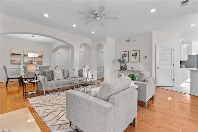 living room with light hardwood / wood-style floors and ceiling fan