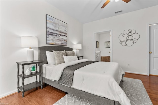 bedroom featuring hardwood / wood-style floors, ceiling fan, and ensuite bathroom