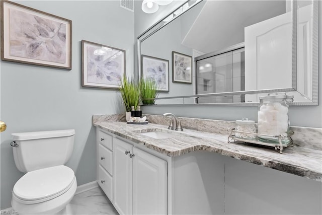 bathroom with vanity, a shower with shower door, and toilet