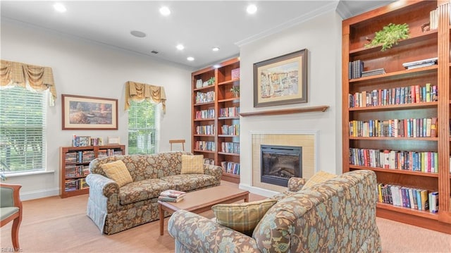 living area with a healthy amount of sunlight, built in features, ornamental molding, and a tiled fireplace