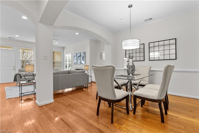 dining area with crown molding and light wood-type flooring