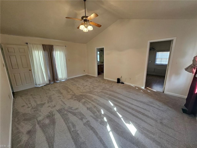 interior space featuring ceiling fan, light carpet, and vaulted ceiling