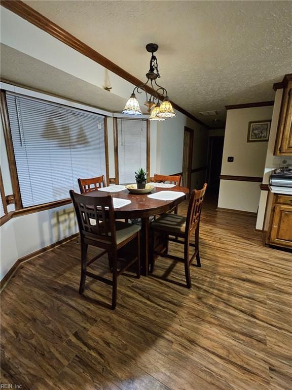 dining area with a textured ceiling, dark hardwood / wood-style floors, an inviting chandelier, and ornamental molding