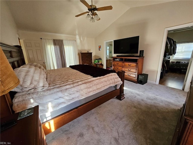 carpeted bedroom with a spacious closet, a closet, vaulted ceiling, and ceiling fan