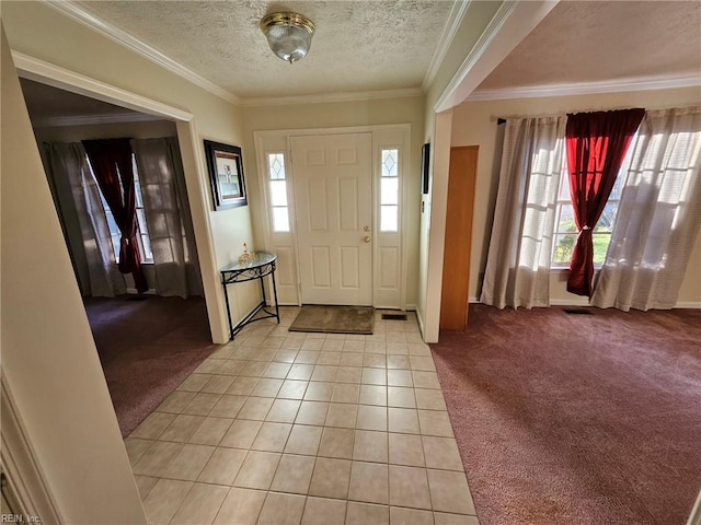 carpeted entrance foyer featuring ornamental molding and a textured ceiling