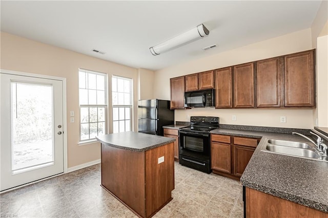 kitchen featuring black appliances, a kitchen island, and sink