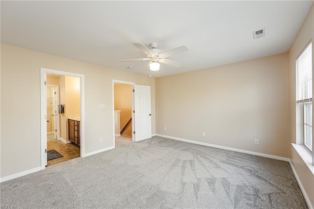 unfurnished bedroom with light carpet, connected bathroom, and ceiling fan